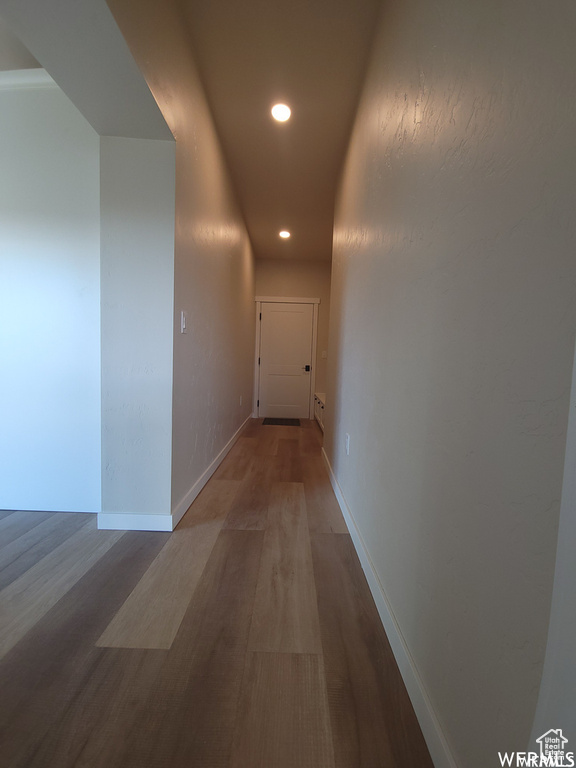 Corridor with hardwood / wood-style floors