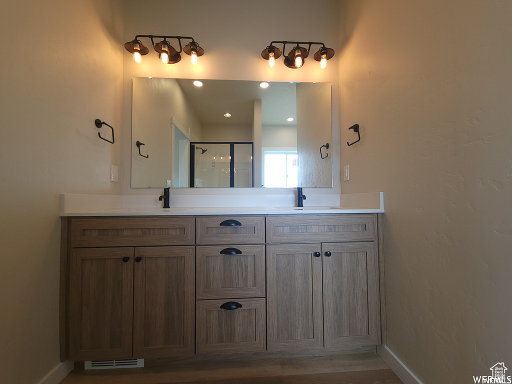 Bathroom with hardwood / wood-style flooring, large vanity, and double sink