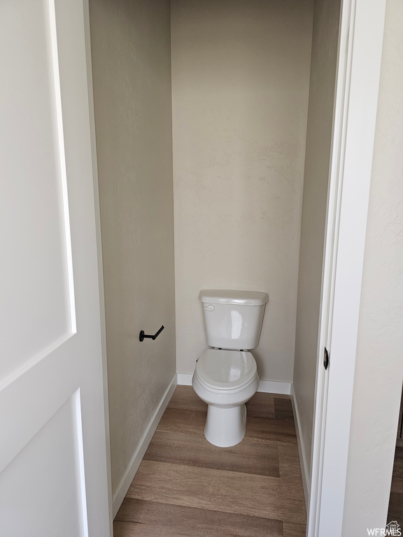 Bathroom with hardwood / wood-style floors and toilet