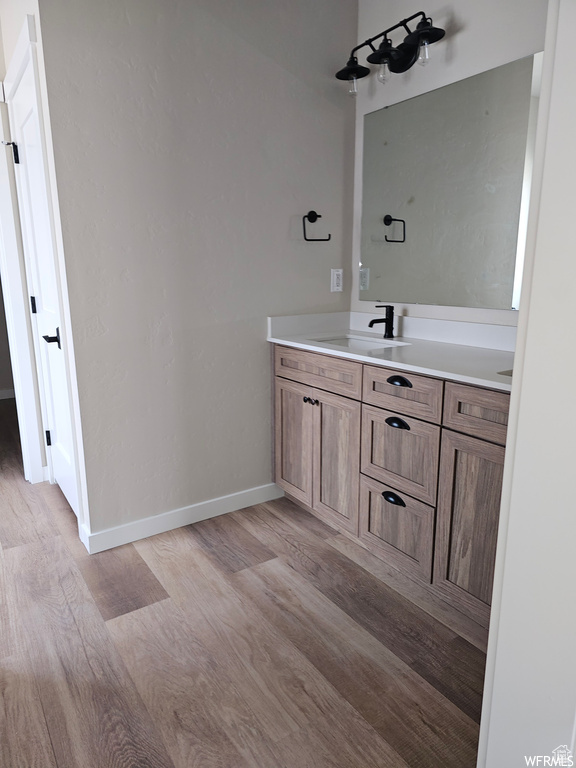 Bathroom featuring vanity with extensive cabinet space and wood-type flooring