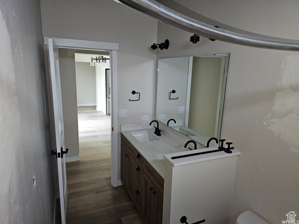 Bathroom featuring oversized vanity, dual sinks, and hardwood / wood-style flooring