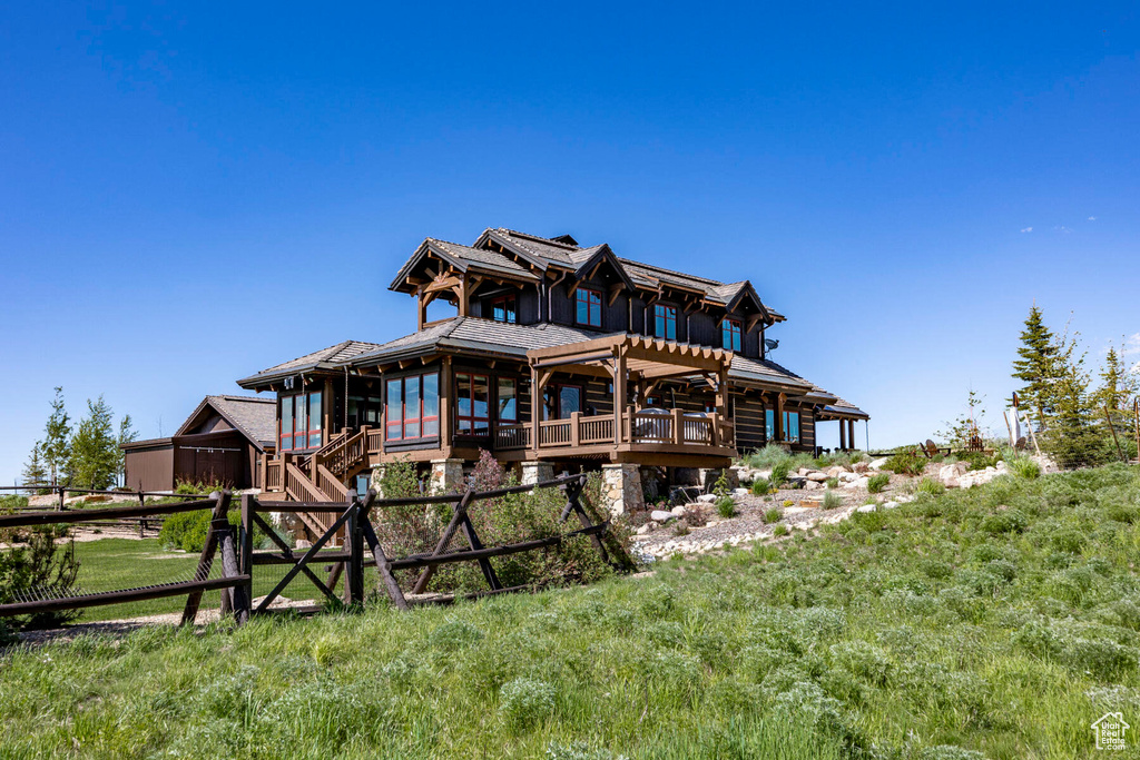 Rear view of house featuring a deck and log exterior