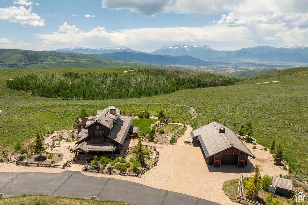 Aerial view of property and surrounding area featuring a mountainous background