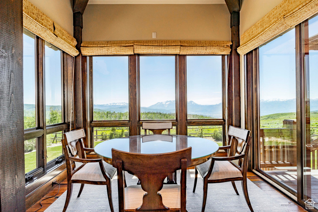 Sunroom / solarium featuring wood finished floors and a mountain view