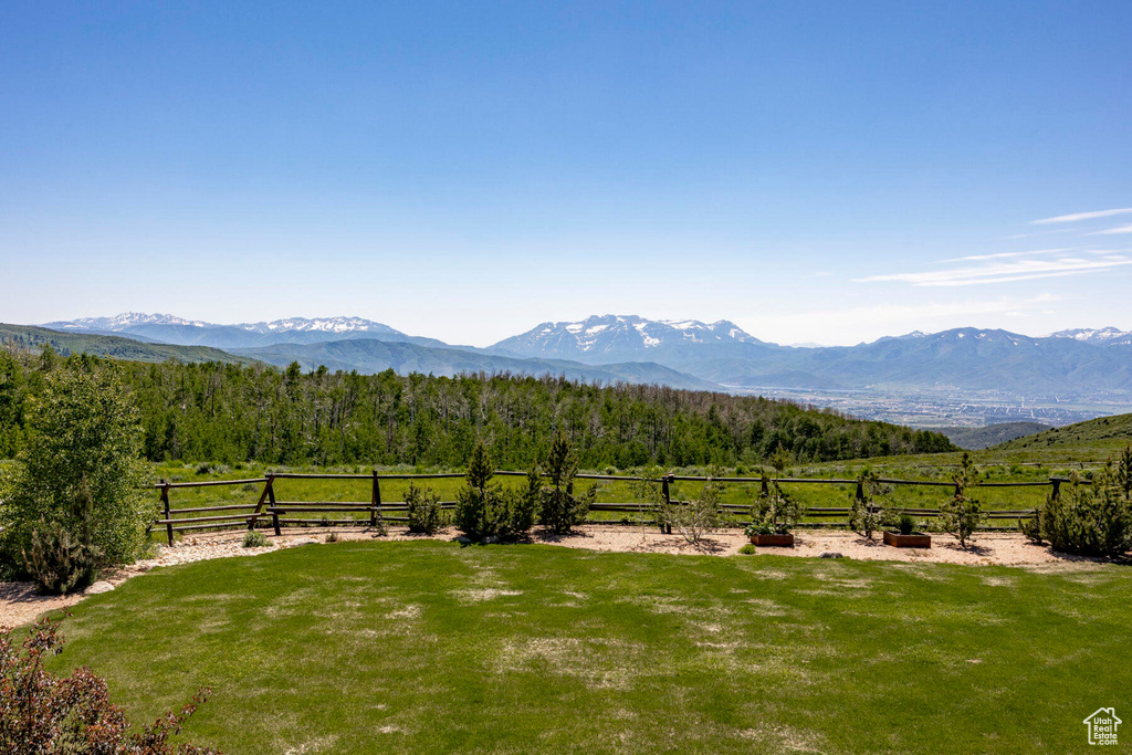 View of mountain backdrop with rural landscape and a forest