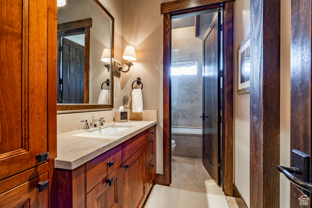 Bathroom featuring vanity, tile patterned flooring, and  shower combination