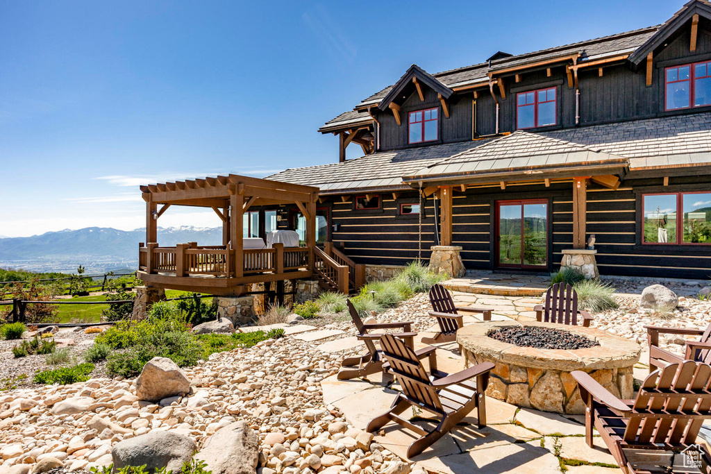 Rear view of house featuring a fire pit, a mountain view, and a pergola