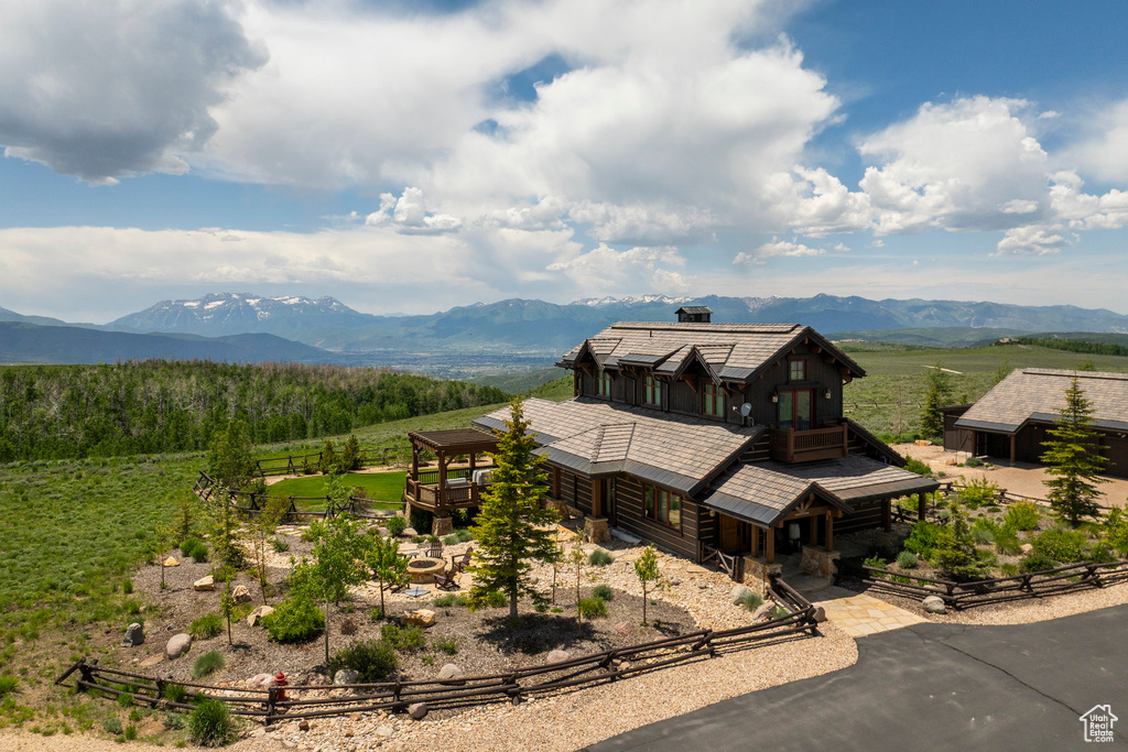 View of front of property with a mountain view and a balcony