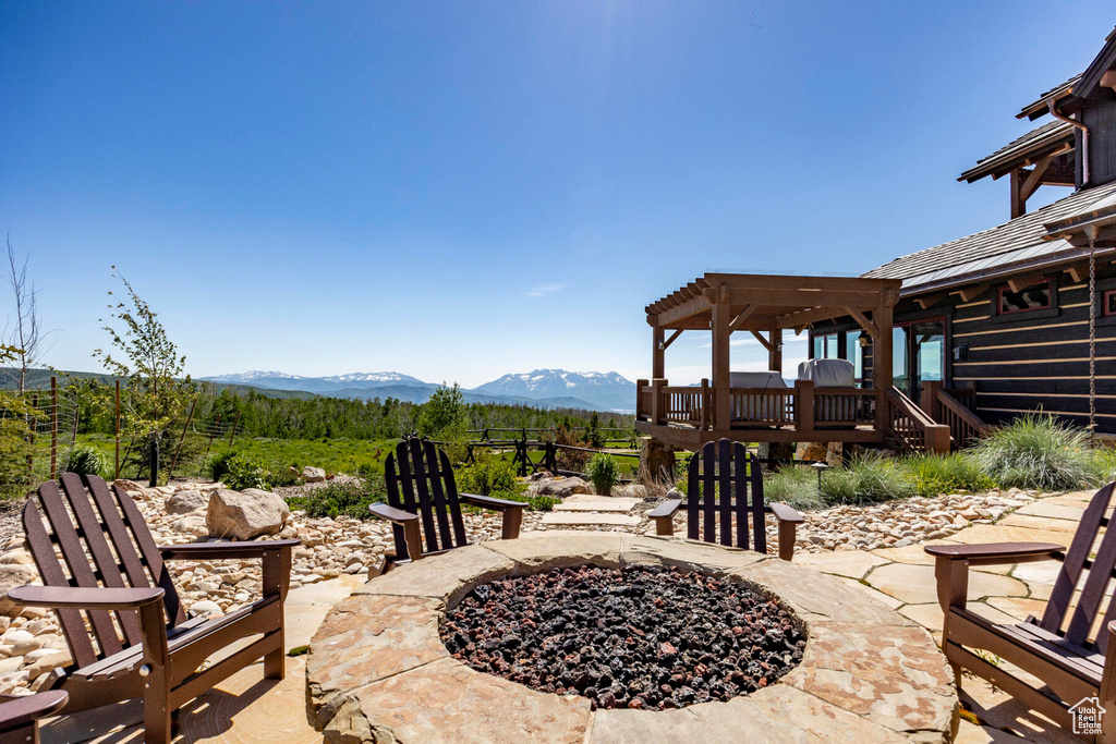 View of patio / terrace with a fire pit, a pergola, and a deck with mountain view