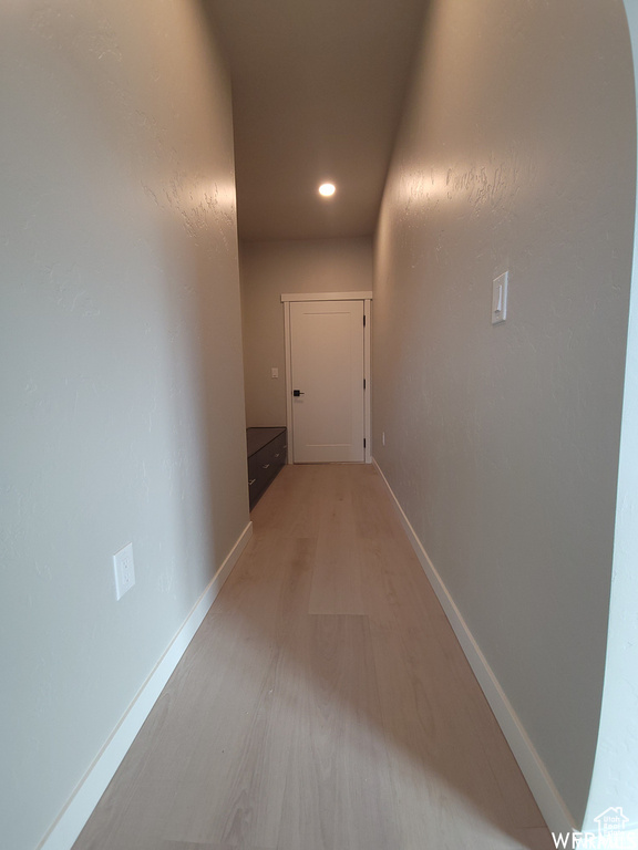 Hallway with hardwood / wood-style floors