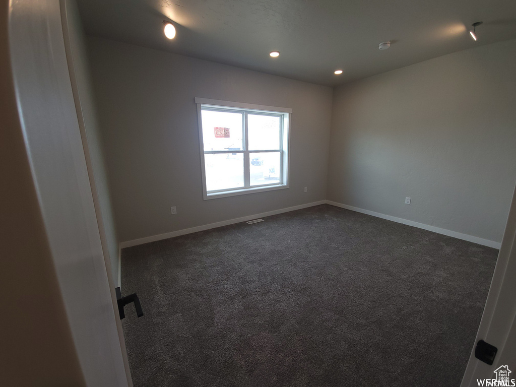 Unfurnished room with dark colored carpet