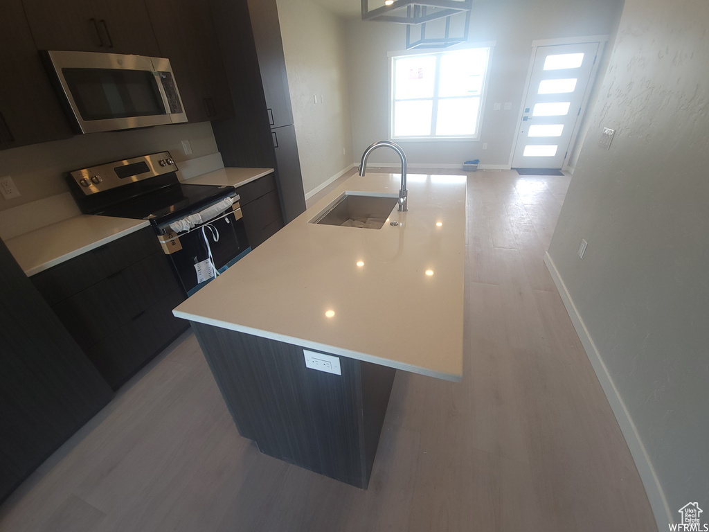 Kitchen featuring appliances with stainless steel finishes, sink, and light hardwood / wood-style flooring