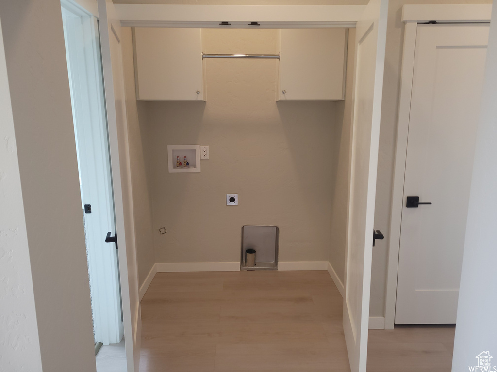 Washroom featuring cabinets, hookup for an electric dryer, light hardwood / wood-style floors, and hookup for a washing machine