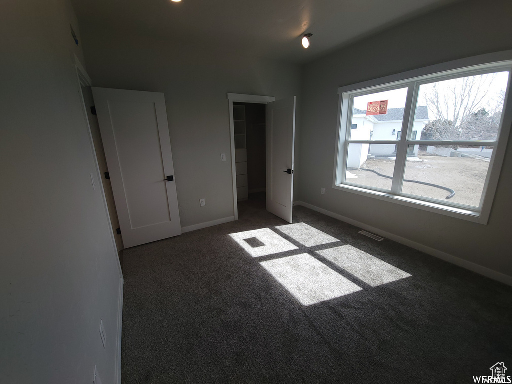 Unfurnished bedroom featuring carpet flooring and a closet