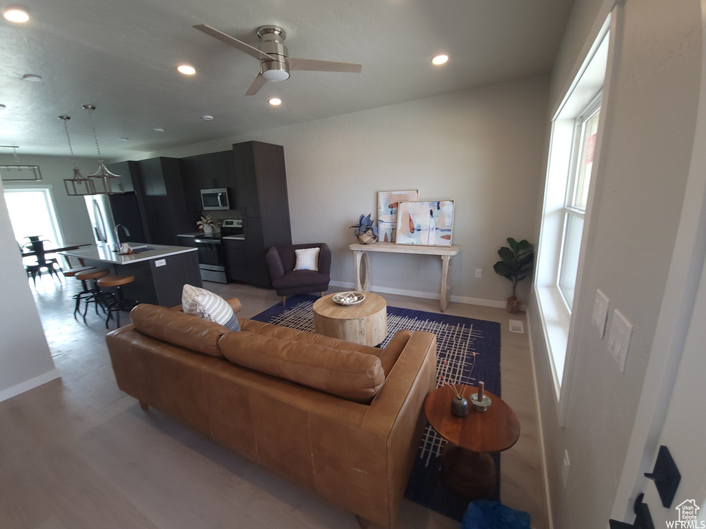 Living room featuring light hardwood / wood-style floors, sink, and ceiling fan