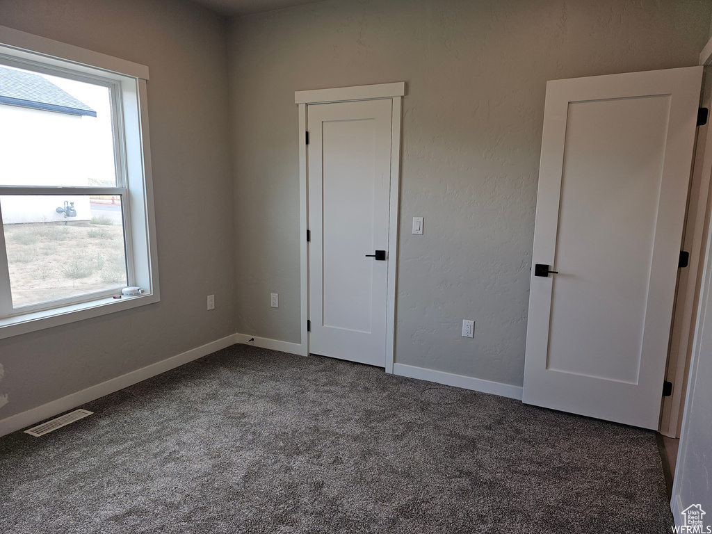 Interior space with a wealth of natural light and dark colored carpet