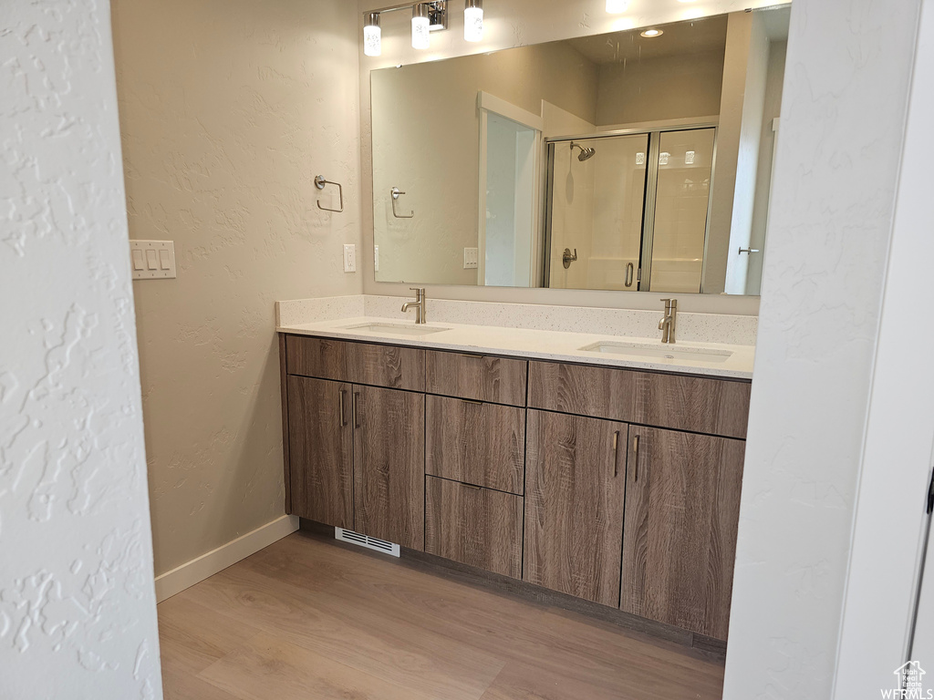 Bathroom with oversized vanity, hardwood / wood-style flooring, and double sink