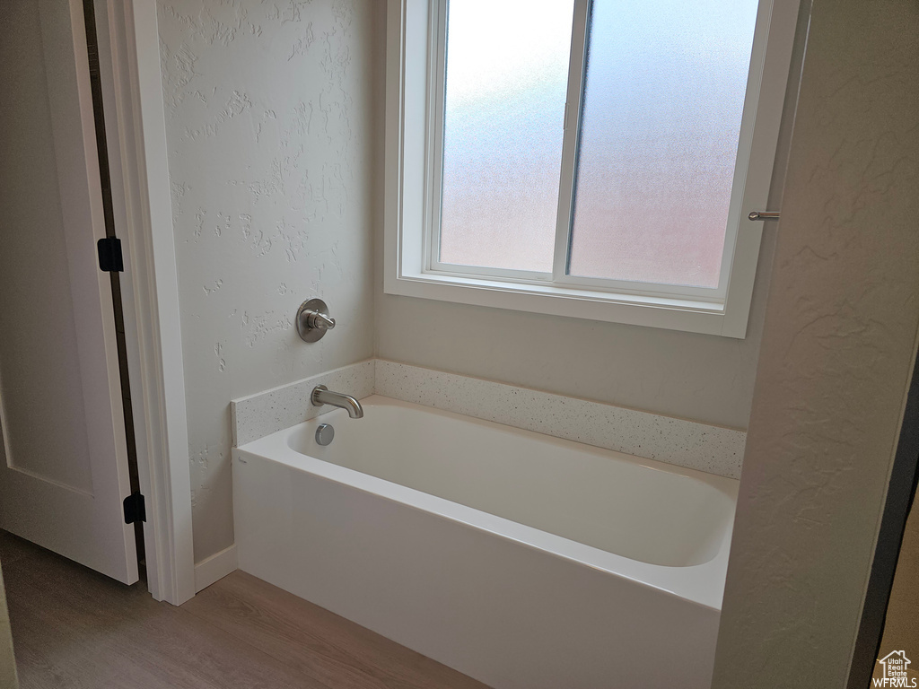 Bathroom featuring hardwood / wood-style floors and a bath