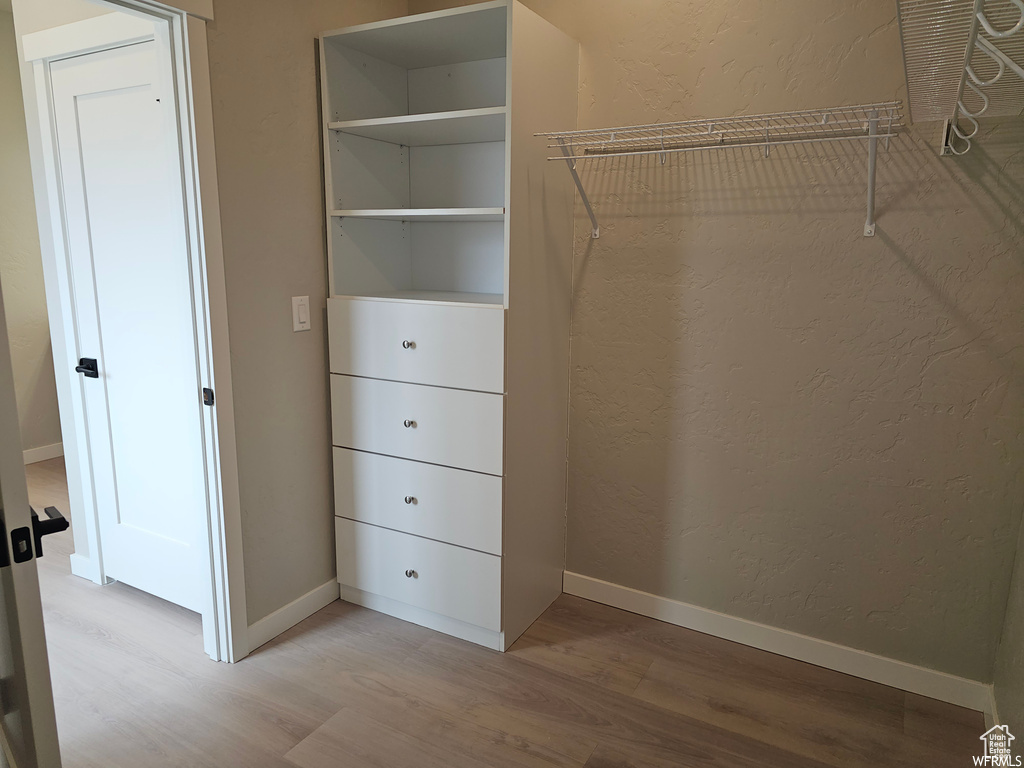 Spacious closet with light hardwood / wood-style floors