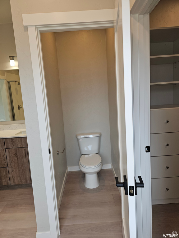 Bathroom featuring hardwood / wood-style flooring, toilet, and vanity