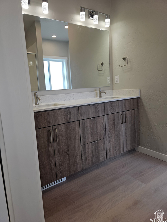 Bathroom featuring wood-type flooring and dual vanity