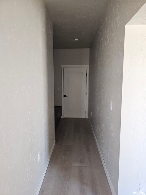 Hallway with hardwood / wood-style flooring