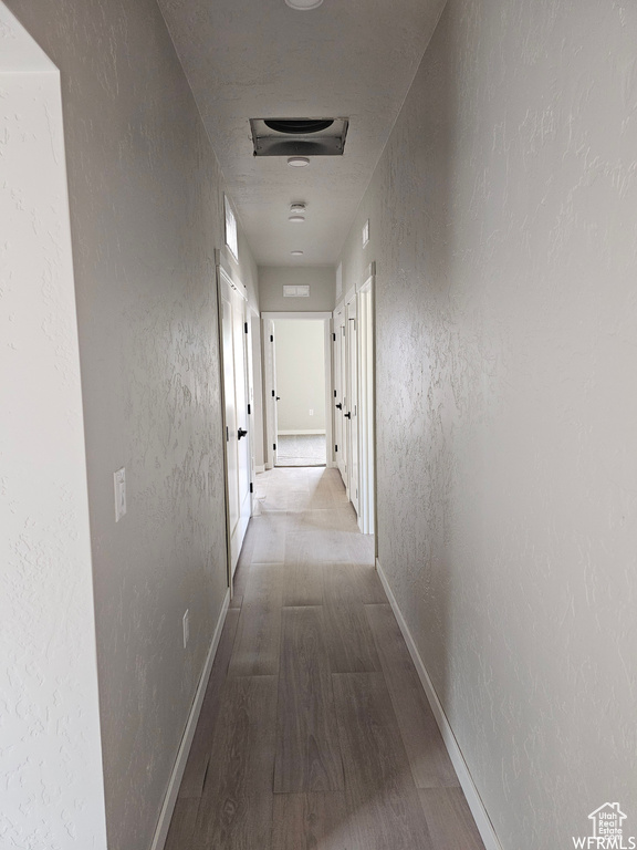 Hallway with hardwood / wood-style floors