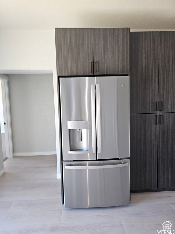 Kitchen with light hardwood / wood-style floors and stainless steel fridge with ice dispenser