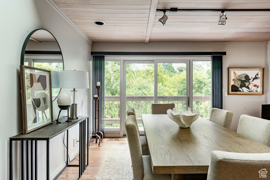 Dining area with track lighting, wood ceiling, and light wood-type flooring