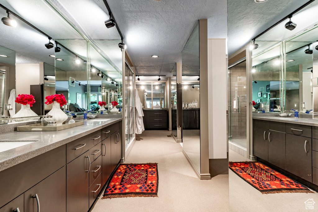 Bathroom featuring double vanity and a textured ceiling