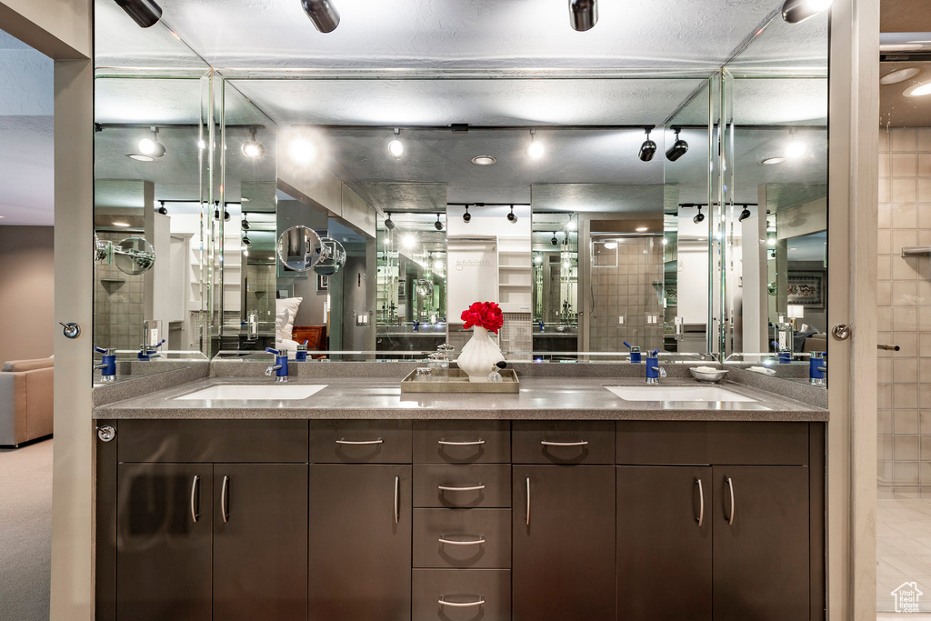 Bathroom featuring double vanity and a textured ceiling