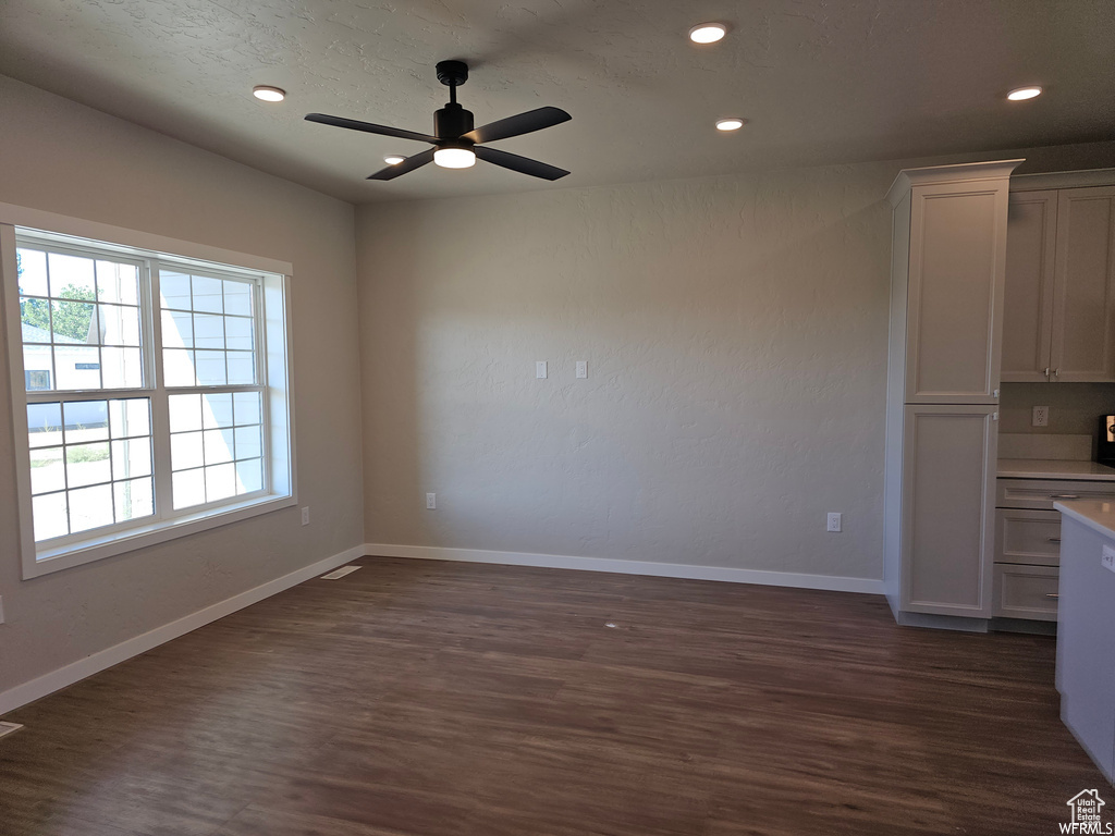 Unfurnished dining area with dark wood-type flooring and ceiling fan