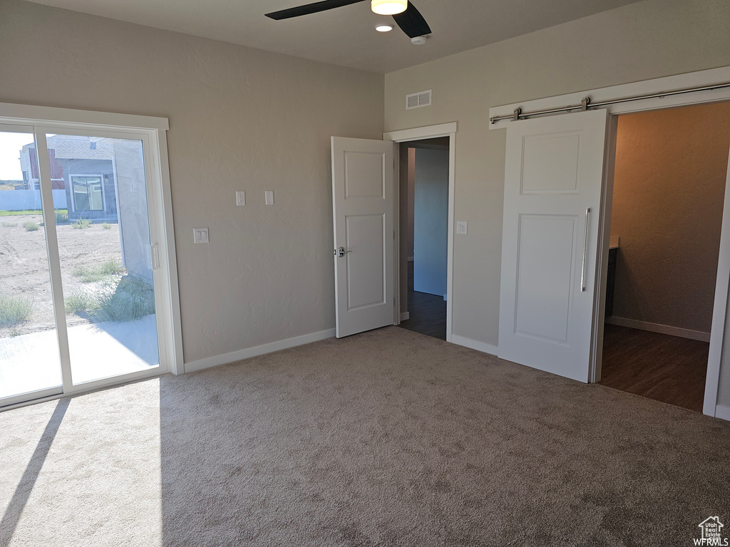 Unfurnished bedroom featuring access to outside, carpet floors, and ceiling fan