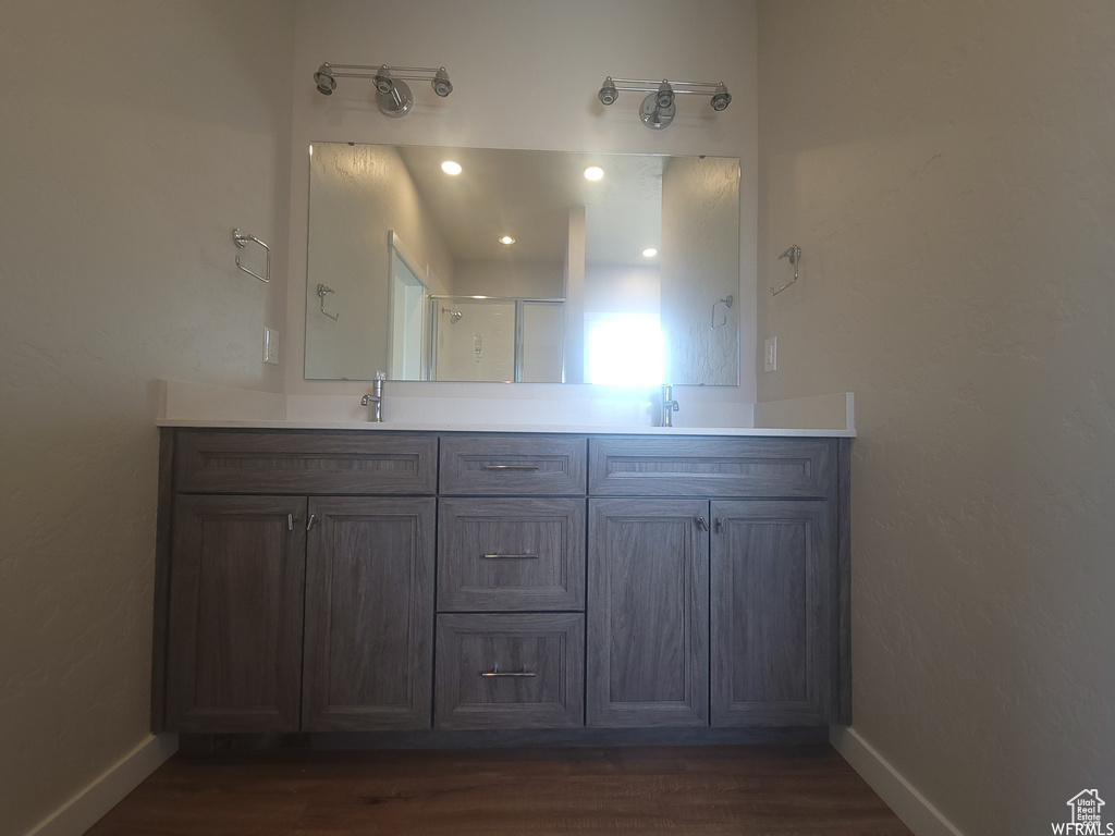 Bathroom with double sink vanity and wood-type flooring