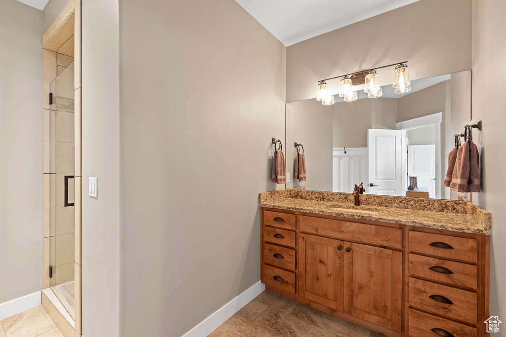 Bathroom featuring walk in shower, tile flooring, and vanity