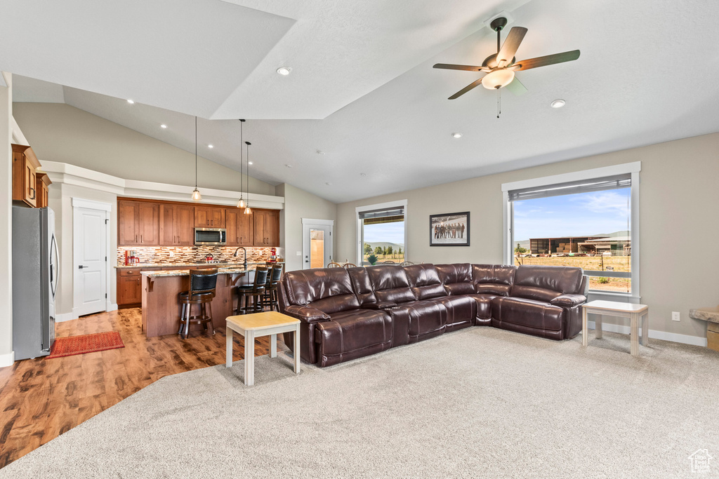 Living room with light hardwood / wood-style floors, a wealth of natural light, sink, and ceiling fan