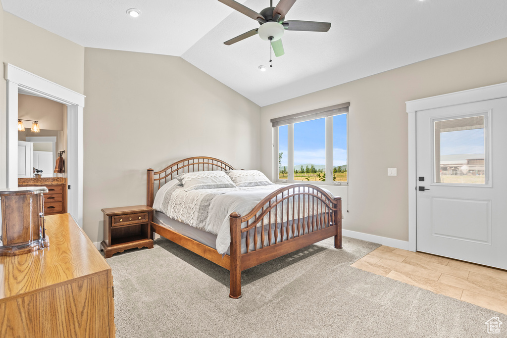 Carpeted bedroom with ceiling fan and vaulted ceiling