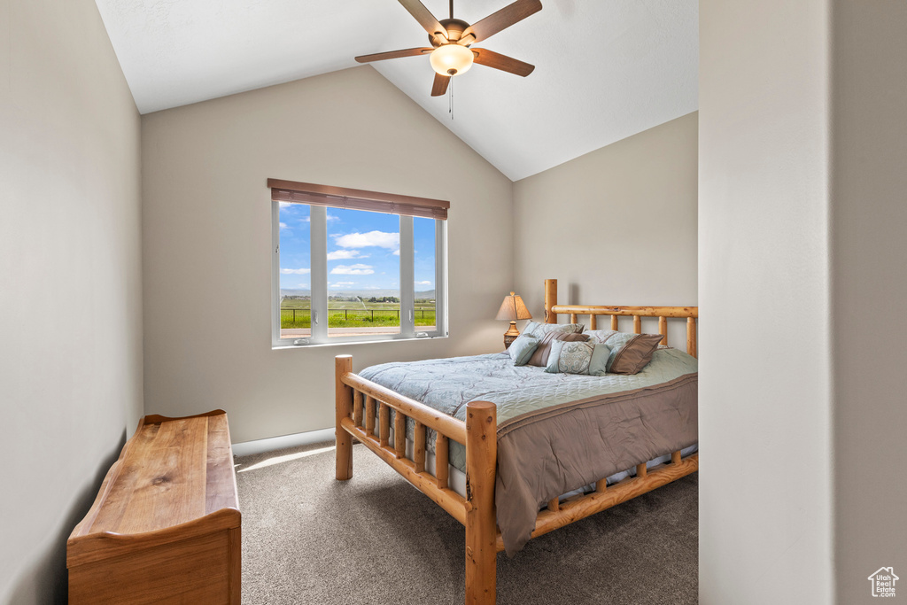 Bedroom featuring vaulted ceiling, ceiling fan, and dark colored carpet