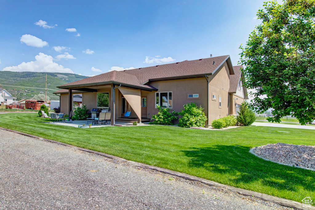 Rear view of house featuring a yard and a patio area