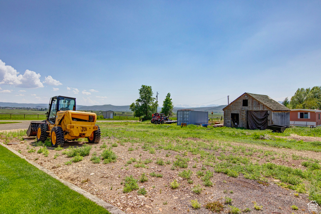 View of yard featuring a mountain view, a shed, and a rural view