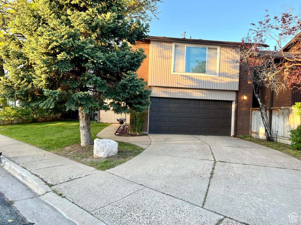 View of front of house with a front lawn and a garage