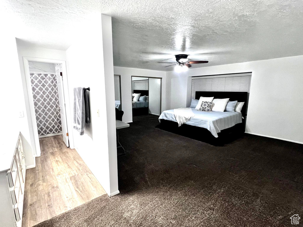 Unfurnished bedroom with a textured ceiling, carpet, and ceiling fan