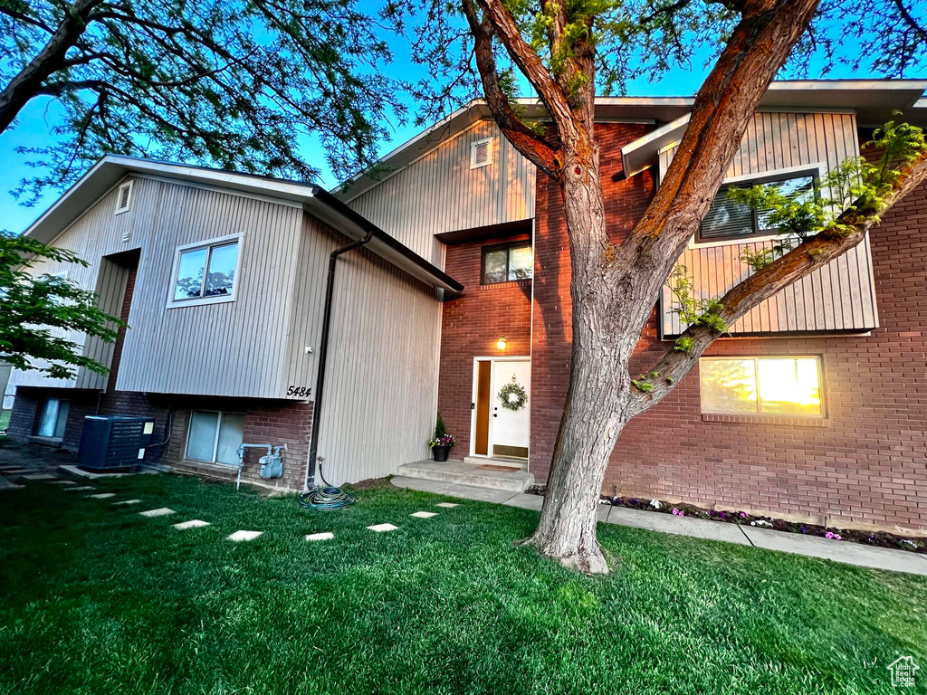 Rear view of house with a yard and central air condition unit