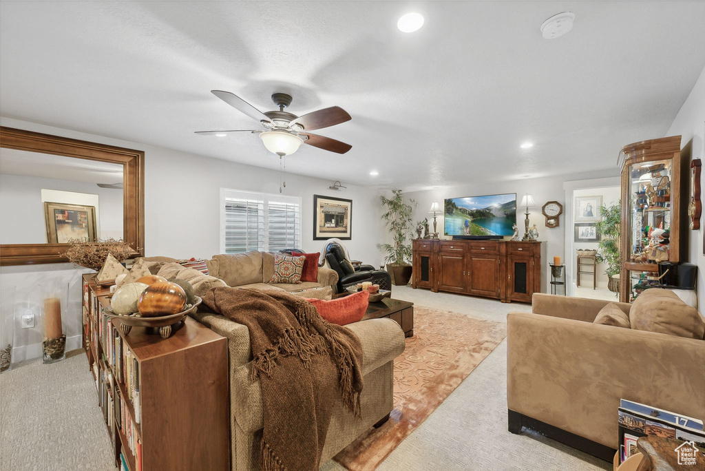 Carpeted living room with ceiling fan