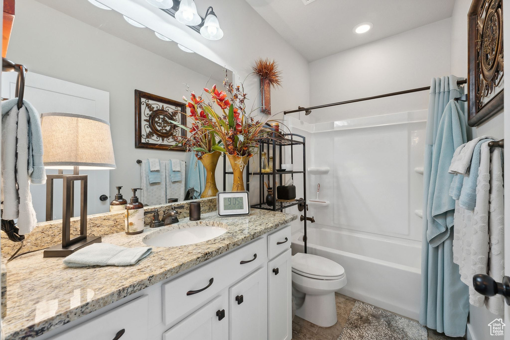 Full bathroom featuring shower / bathing tub combination, vanity with extensive cabinet space, tile floors, and toilet