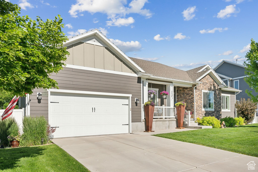 Craftsman-style home featuring a garage and a front lawn