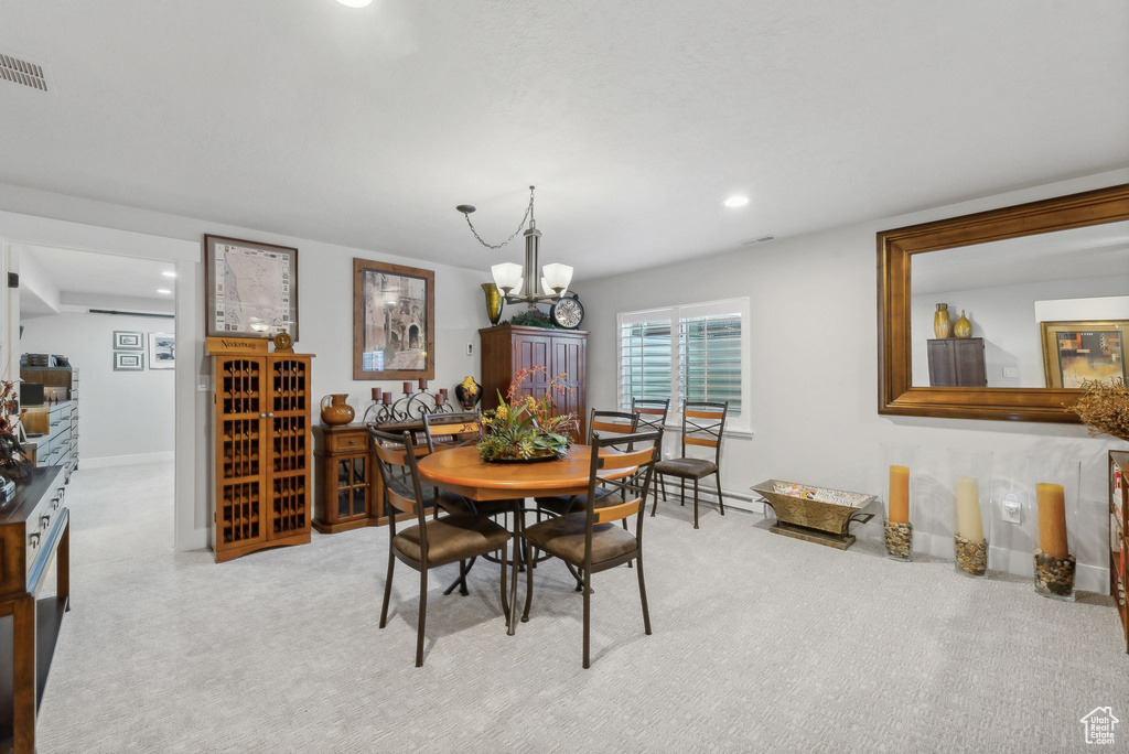 Carpeted dining area featuring a chandelier