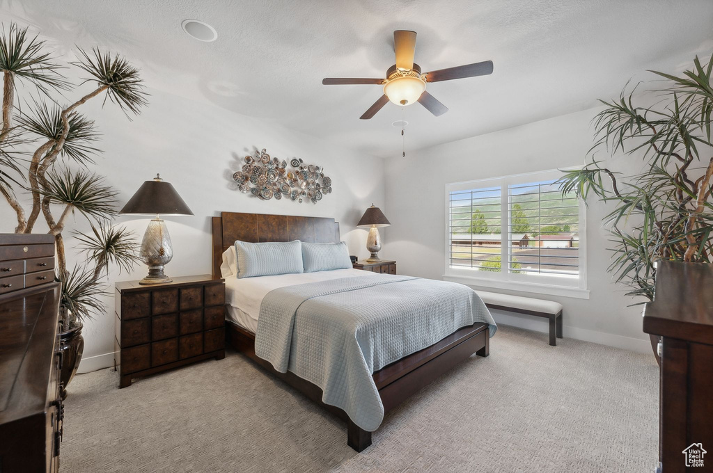 Bedroom with light carpet and ceiling fan