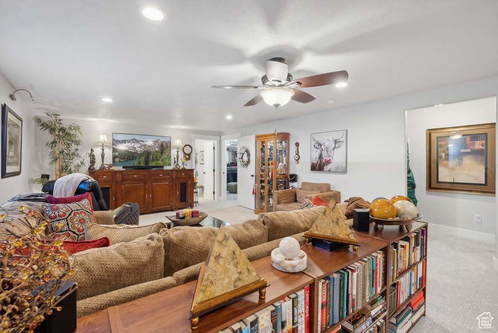 Carpeted living room with ceiling fan