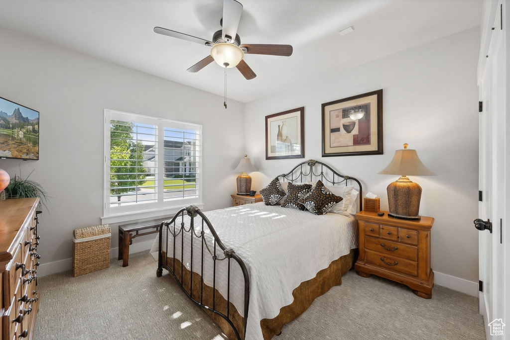 Bedroom with ceiling fan and light colored carpet